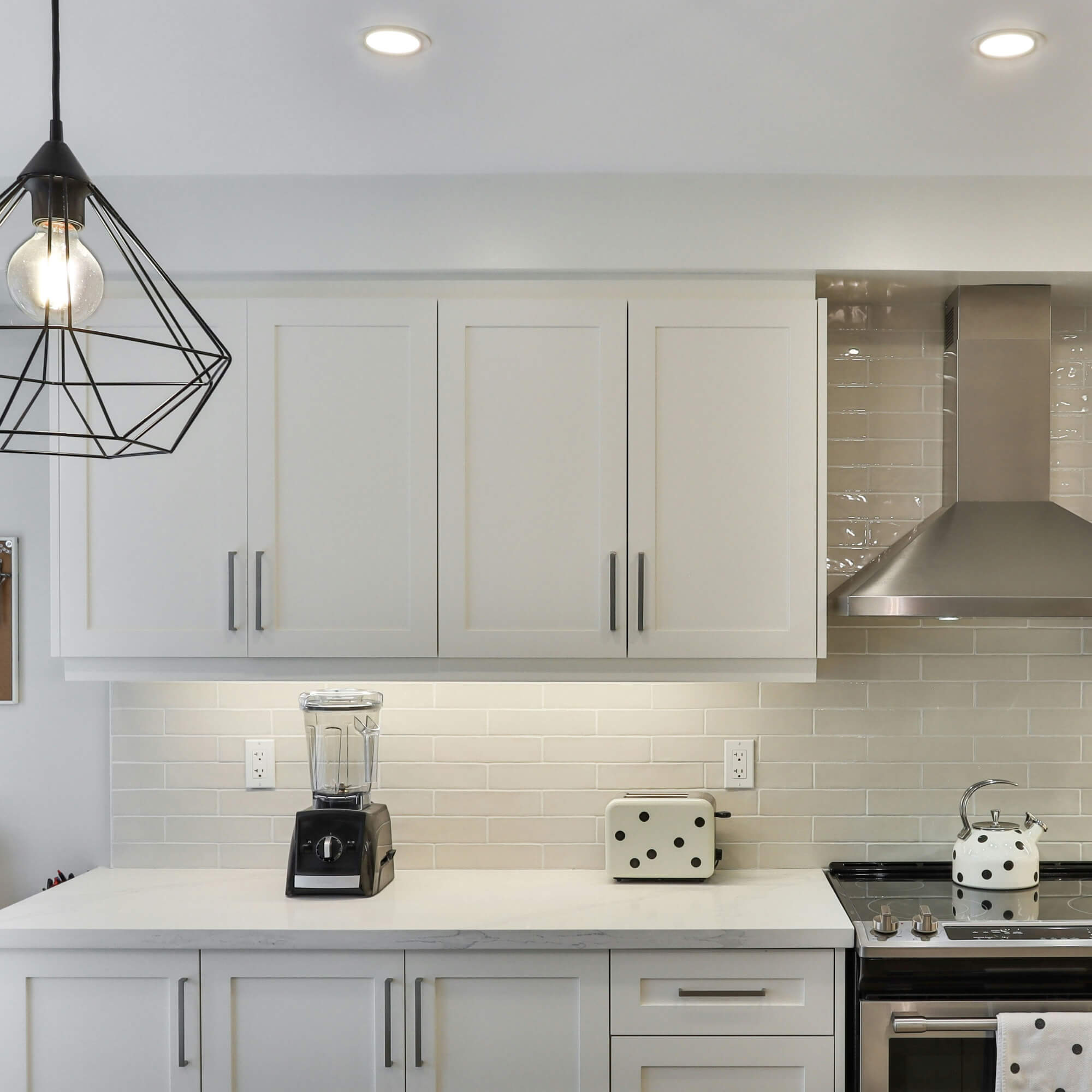 Modern kitchen with painted Shaker cabinet doors – white flat panel upper and lower cabinets with brushed metal handles